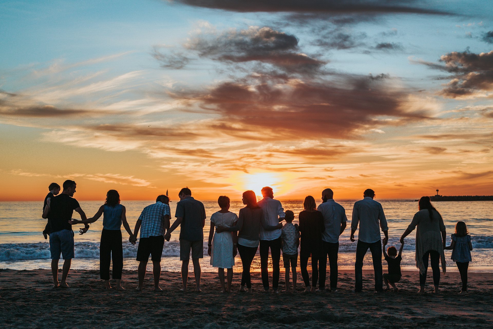 A family walking on the beach at sunset
